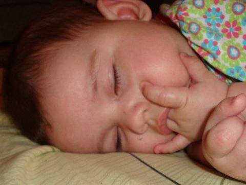 Сую пальцы спящей. Малыш с пальцем во рту. Пальцы во рту у грудничка. Сосание кулачков у новорожденных.