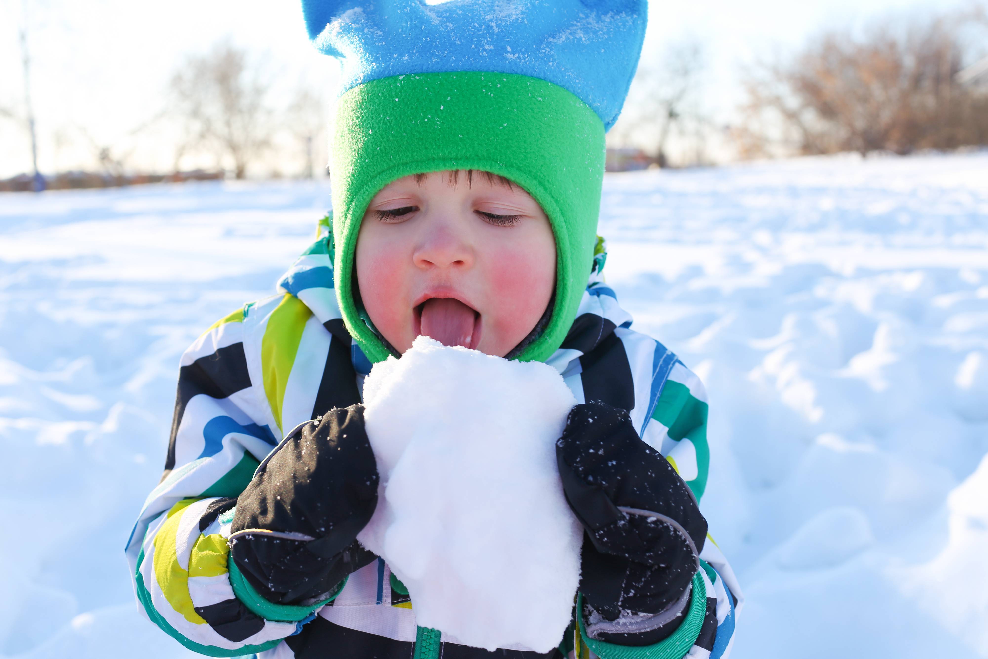Ребенок ест снег. Мальчик зимой. Кушать снег. Дети едят снег и сосульки.