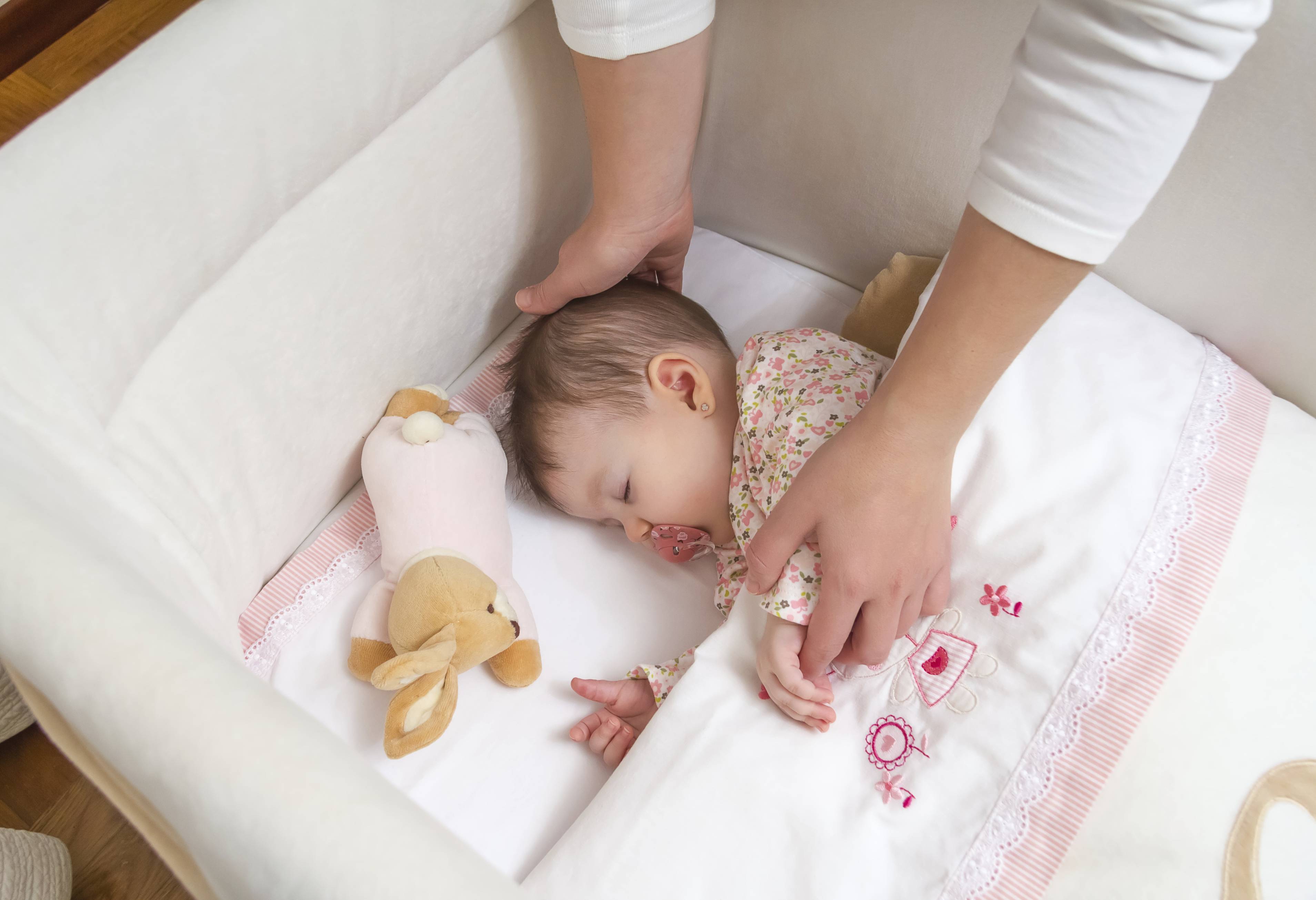 Когда можно выкладывать ребенка. Укладывание в кроватку новорожденному. Подушка для укладывания ребенка. Укладывание малышка в кроватку. Правильное укладывание грудничка на сон.