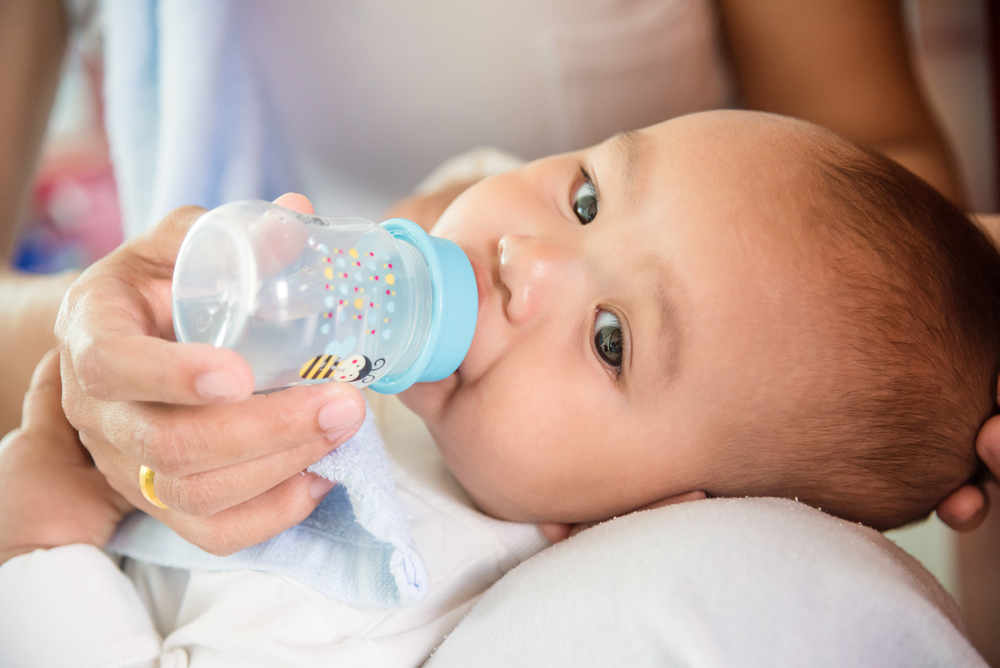 Можно ли пить грудному ребенку пить. Малыш с бутылочкой. Бутылочка для кормления. Вода для новорожденных при грудном вскармливании. Питье для новорожденного ребенка.